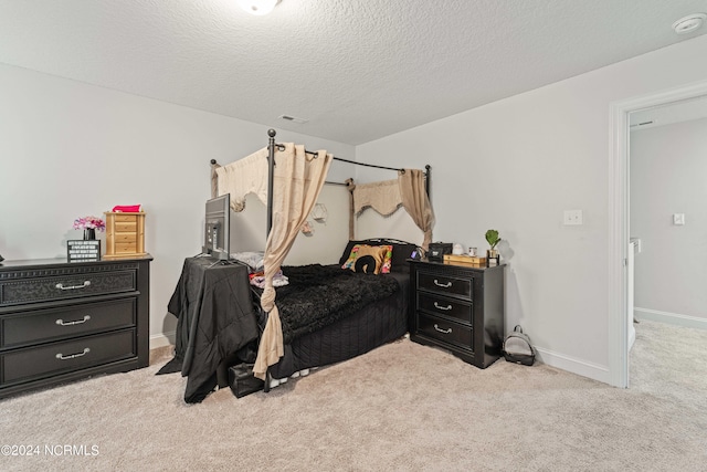 bedroom featuring light colored carpet and a textured ceiling