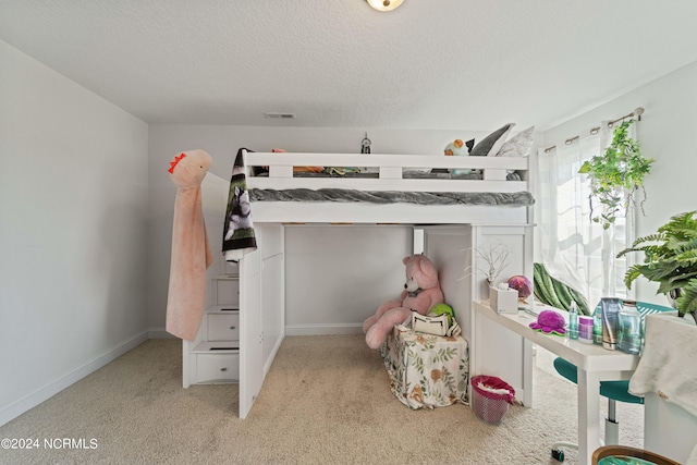 bedroom featuring light carpet and a textured ceiling