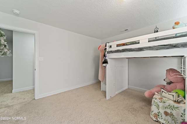 carpeted bedroom with a textured ceiling