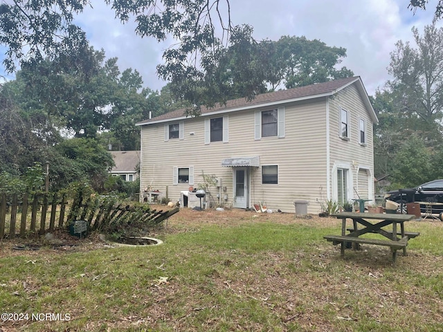 rear view of house featuring a lawn