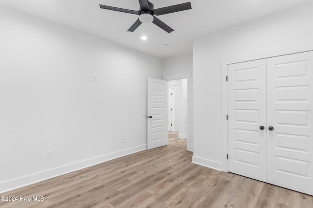 unfurnished bedroom with light hardwood / wood-style flooring, a closet, and ceiling fan