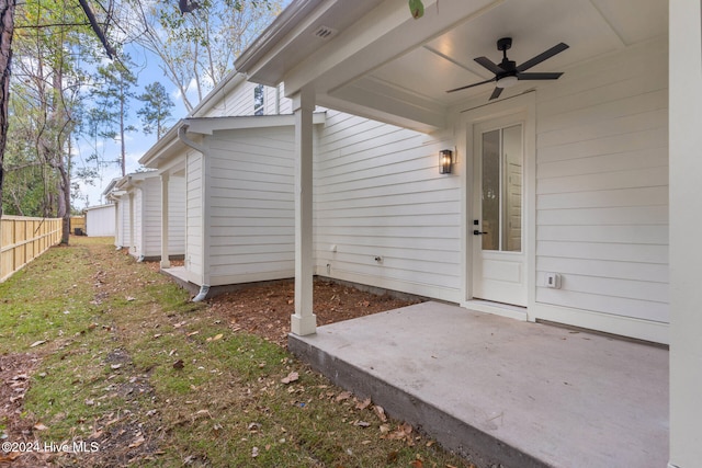 view of exterior entry with a patio area and ceiling fan