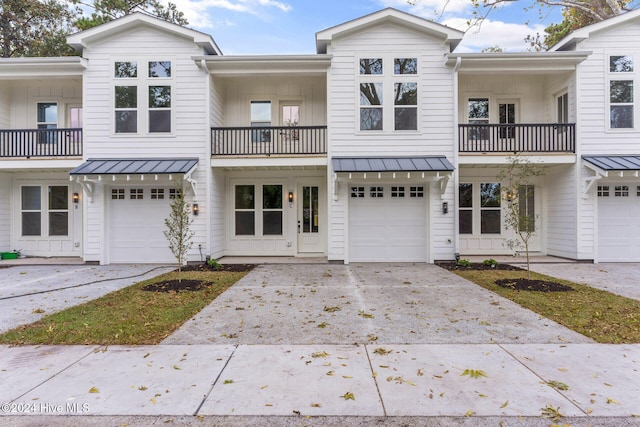 townhome / multi-family property featuring a balcony and a garage