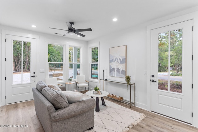 living room with light hardwood / wood-style floors and ceiling fan