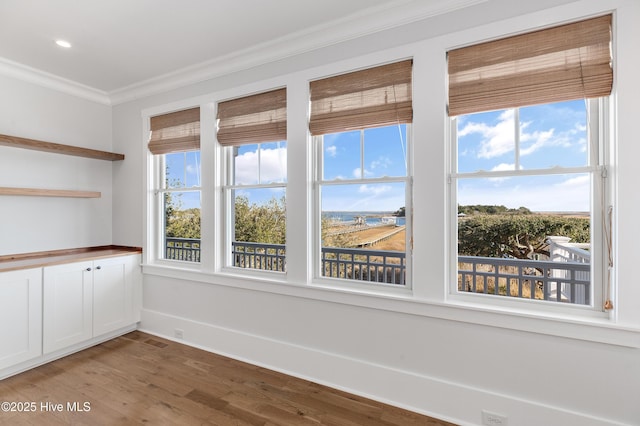 spare room featuring hardwood / wood-style flooring and ornamental molding