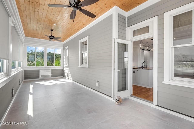 unfurnished sunroom featuring wooden ceiling and ceiling fan