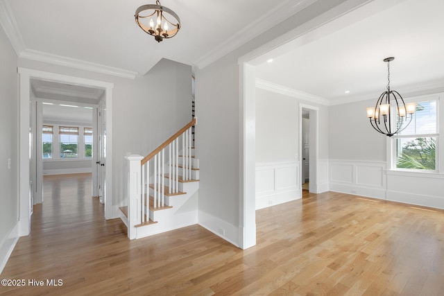 interior space featuring hardwood / wood-style flooring, crown molding, and a notable chandelier