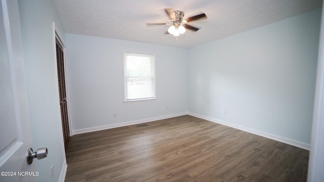 spare room with ceiling fan and dark wood-type flooring