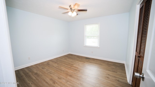 unfurnished bedroom with ceiling fan, a closet, and dark hardwood / wood-style floors