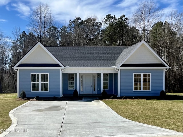 ranch-style home featuring driveway, a shingled roof, a porch, and a front lawn