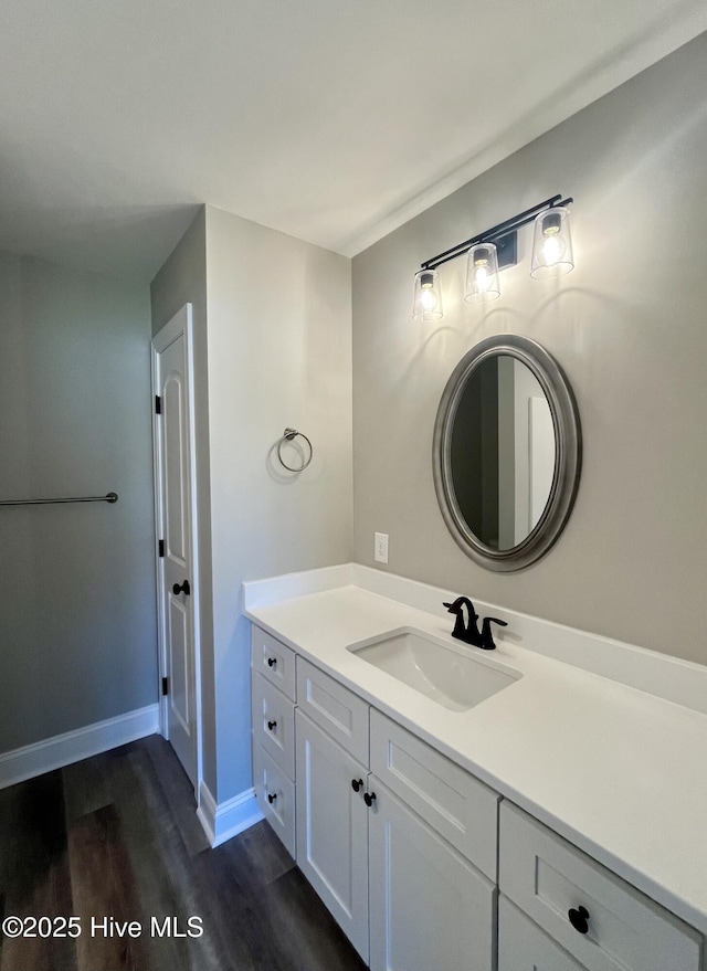 bathroom with vanity, baseboards, and wood finished floors