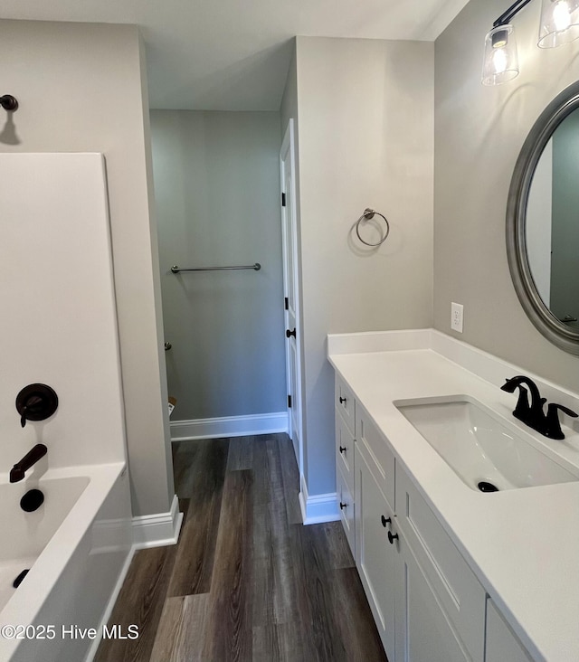 bathroom featuring wood finished floors, vanity, and baseboards