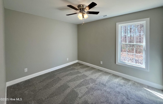 carpeted spare room with visible vents, ceiling fan, and baseboards