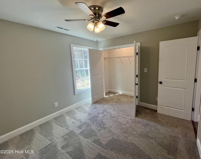 unfurnished bedroom featuring carpet floors, baseboards, visible vents, and a closet