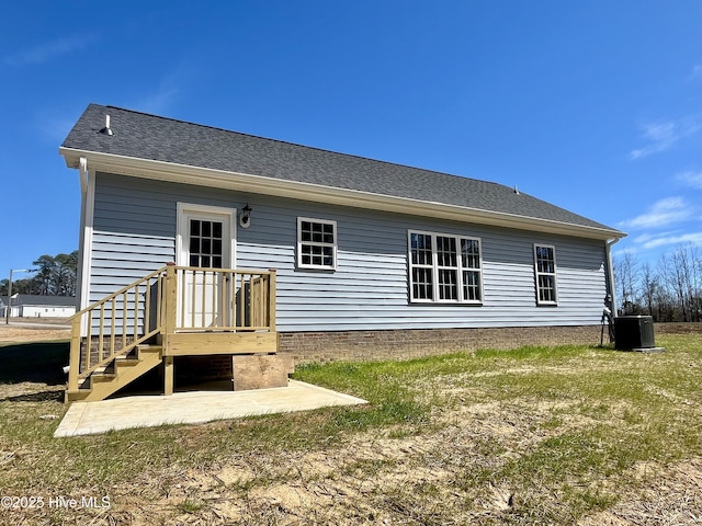 back of house featuring a shingled roof and central AC unit