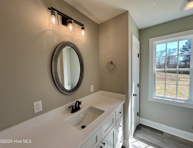 bathroom with baseboards, visible vents, wood finished floors, and vanity