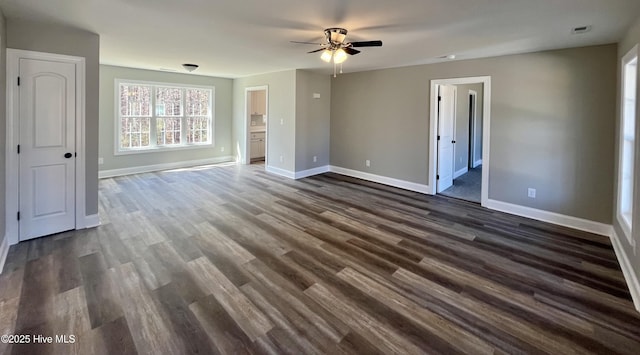 unfurnished bedroom featuring ensuite bath, dark wood finished floors, visible vents, and baseboards