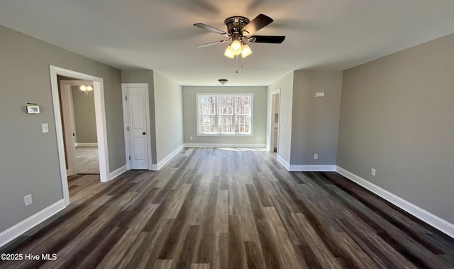 unfurnished living room with dark wood-type flooring, baseboards, and a ceiling fan