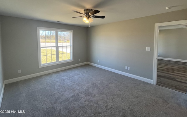 unfurnished room with dark colored carpet, ceiling fan, and baseboards