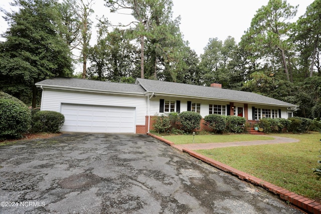 ranch-style house with aphalt driveway, brick siding, a chimney, a garage, and a front lawn