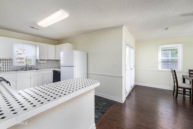 kitchen featuring white cabinets, dark hardwood / wood-style floors, white fridge, and tasteful backsplash