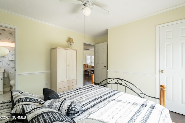 bedroom featuring crown molding, ensuite bath, ceiling fan, and dark hardwood / wood-style flooring