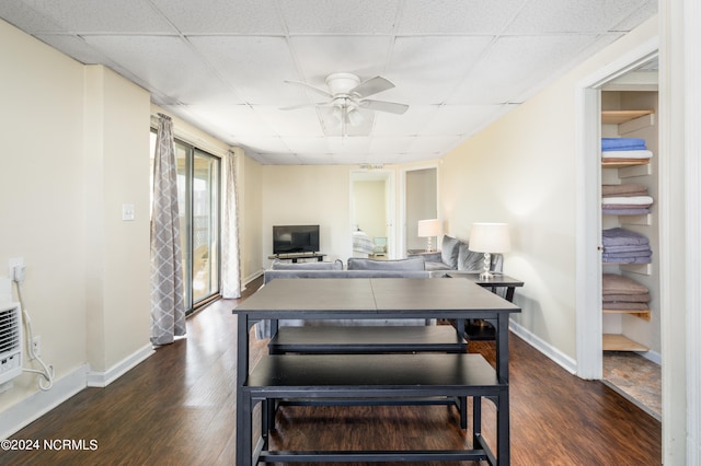 dining space featuring ceiling fan, a drop ceiling, and dark hardwood / wood-style flooring