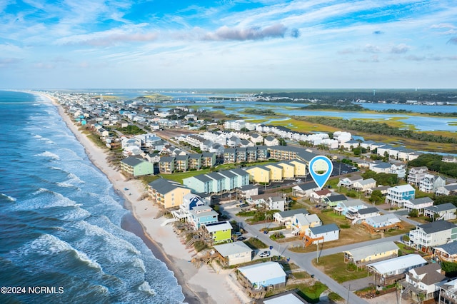 birds eye view of property featuring a water view and a beach view