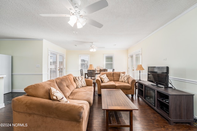 living room with a textured ceiling, ornamental molding, dark hardwood / wood-style flooring, and ceiling fan