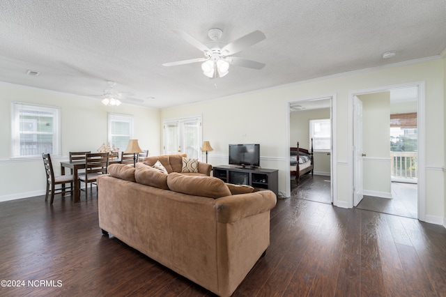 living room featuring ceiling fan, a textured ceiling, dark hardwood / wood-style flooring, and a wealth of natural light