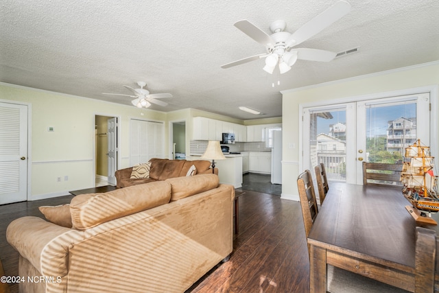 living room with ceiling fan, dark wood-type flooring, and a textured ceiling