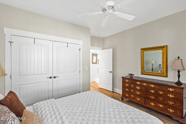 bedroom with hardwood / wood-style flooring, ceiling fan, and a closet