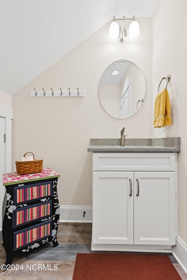 bathroom featuring vanity, vaulted ceiling, and hardwood / wood-style floors