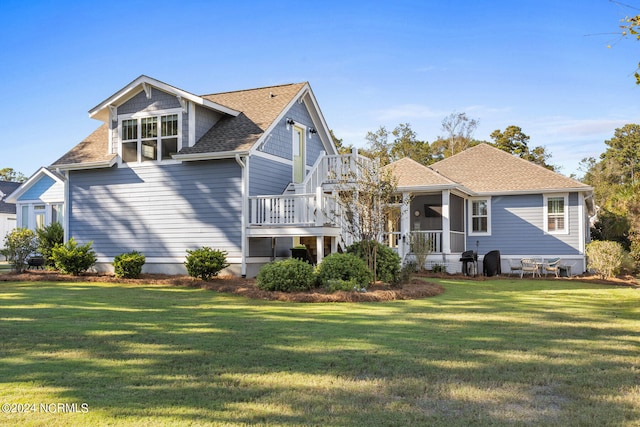 back of property with a wooden deck and a lawn