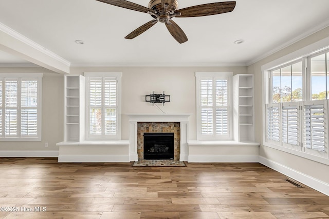 unfurnished living room featuring crown molding, hardwood / wood-style floors, built in features, and ceiling fan