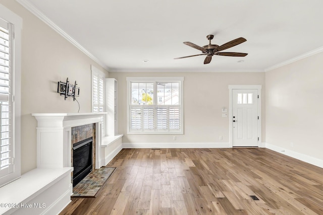 unfurnished living room with hardwood / wood-style floors, a fireplace, ornamental molding, and ceiling fan