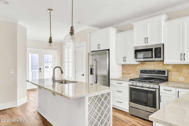 kitchen with sink, hanging light fixtures, a center island with sink, appliances with stainless steel finishes, and white cabinets