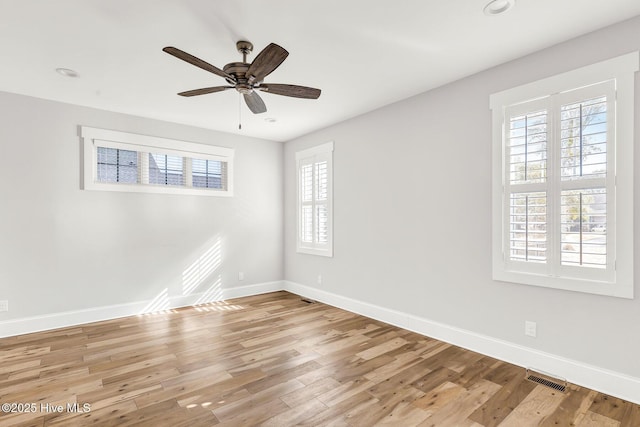 empty room with ceiling fan and light hardwood / wood-style flooring