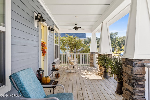 wooden terrace featuring covered porch and ceiling fan