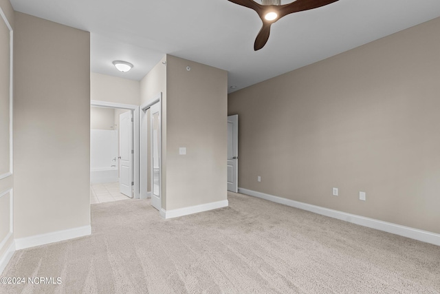 unfurnished bedroom with ceiling fan, light carpet, and ensuite bathroom