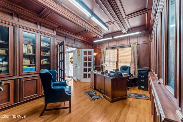 home office featuring light wood-style floors, coffered ceiling, crown molding, and wooden walls