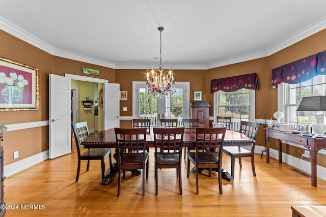 dining area with ornamental molding, light wood-style flooring, baseboards, and an inviting chandelier