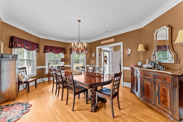 dining area featuring crown molding, light wood finished floors, and a notable chandelier