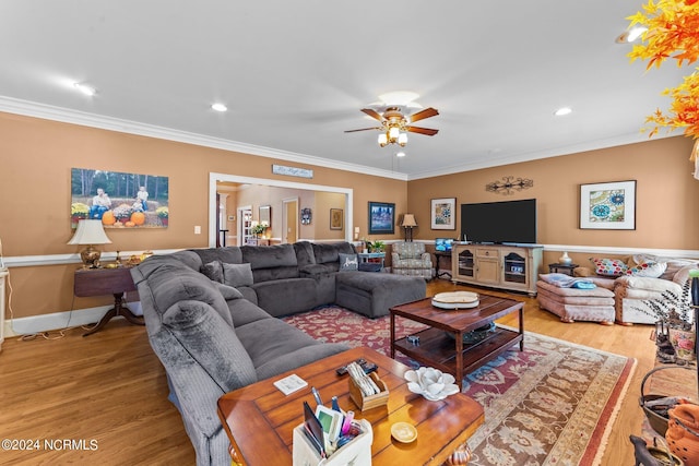 living room featuring crown molding, light wood finished floors, and ceiling fan