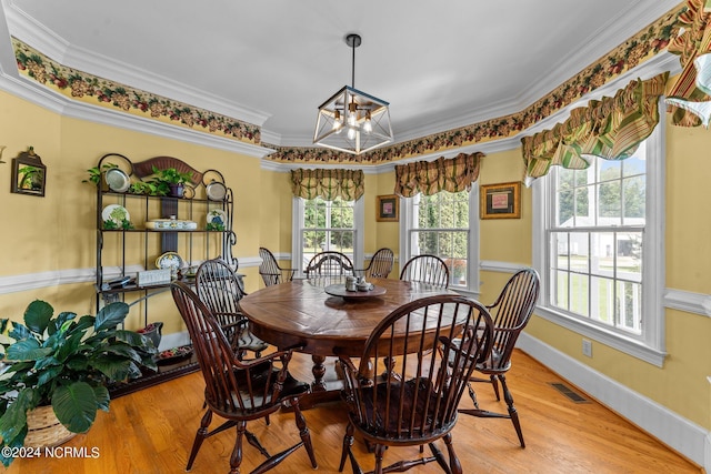 dining area featuring a notable chandelier, wood finished floors, visible vents, baseboards, and ornamental molding