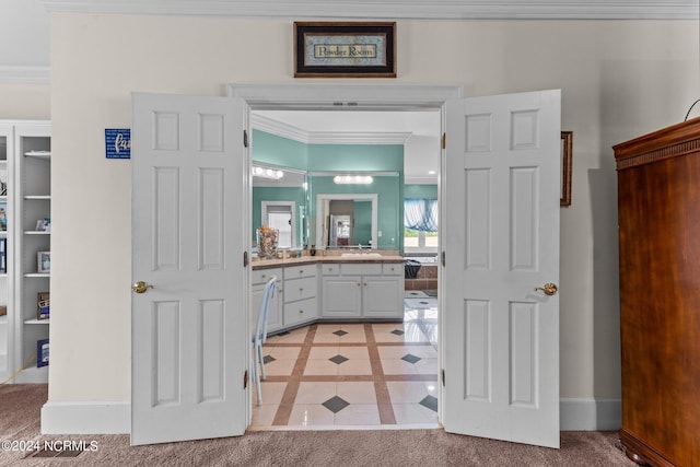 bathroom with ornamental molding, vanity, baseboards, and tile patterned floors