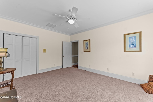 bedroom featuring baseboards, a ceiling fan, crown molding, carpet floors, and a closet