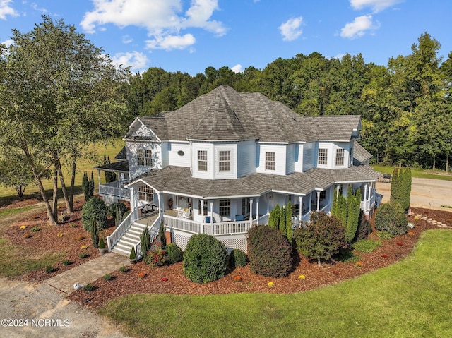 view of front of property featuring stairs and a front lawn