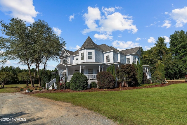 victorian house featuring a porch and a front yard