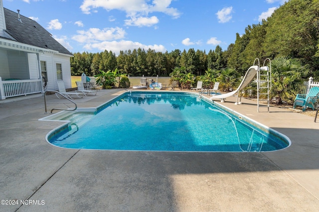 view of pool with a fenced in pool, a water slide, a patio, and fence